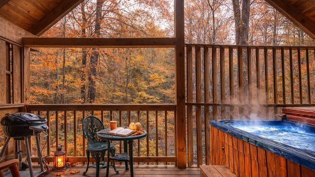 A wooden deck with a hot tub, a grill, and a table with chairs. - Mountain Eden, Hot Tub, Resort Pool, WIFI, $560 FREE tickets each paid day!!! (Gatlinburg)