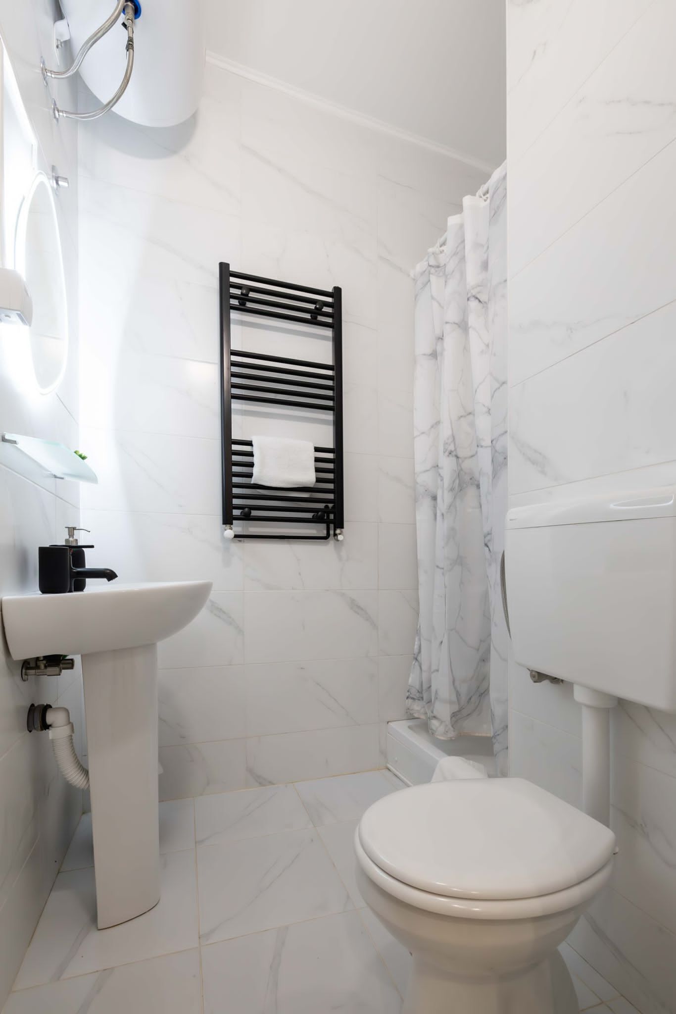 A modern bathroom with a white sink, toilet, and shower.