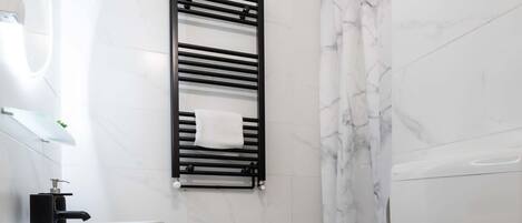 A modern bathroom with a white sink, toilet, and shower.