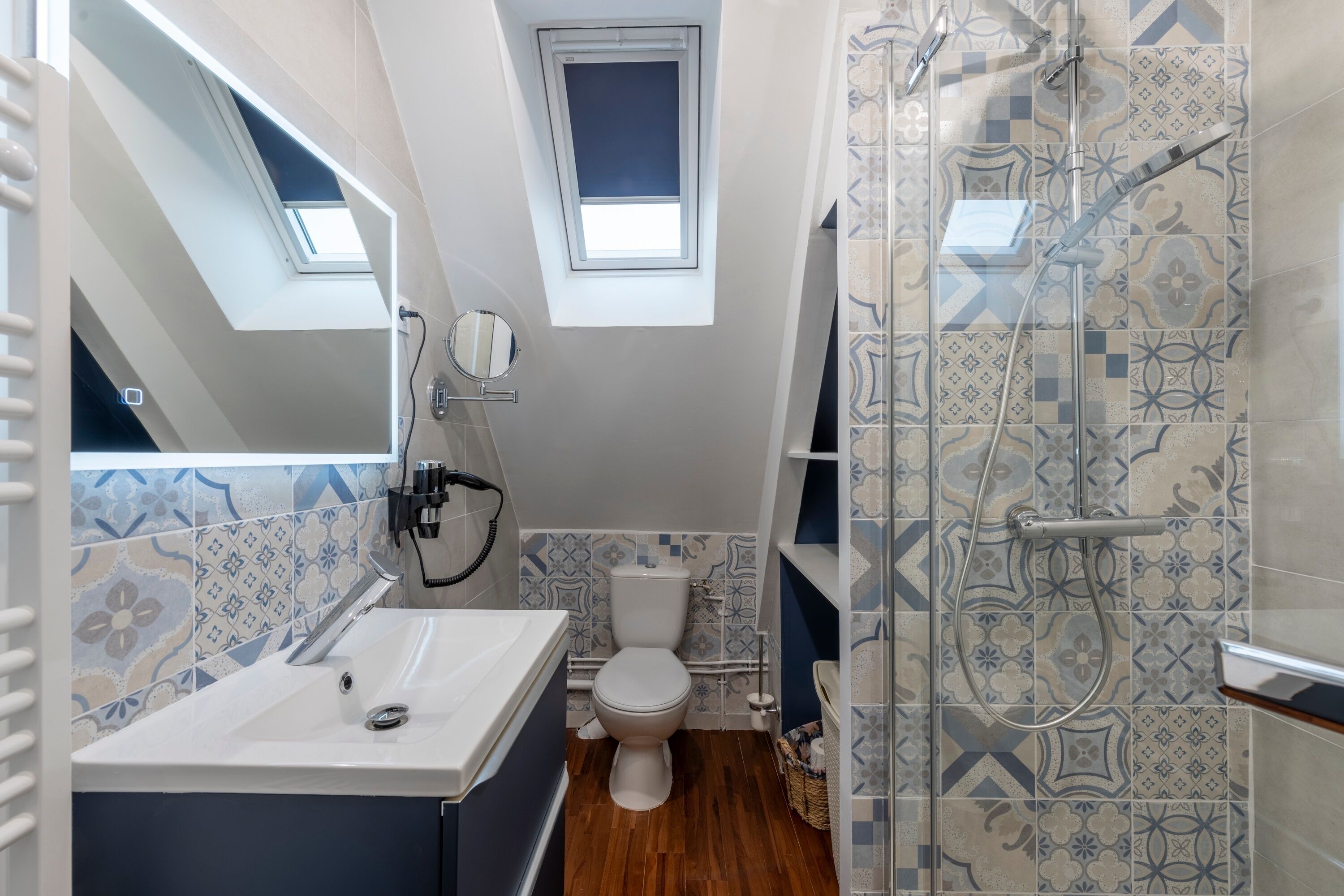 A compact bathroom with a skylight, a shower with a glass door, and a toilet.