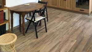 A kitchen with wooden cabinets, a dining table with chairs, and a built-in oven. - Superbe T2 Neuf à Carry le Rouet Avec Toit Terrasse Privatif (Carry-le-Rouet)