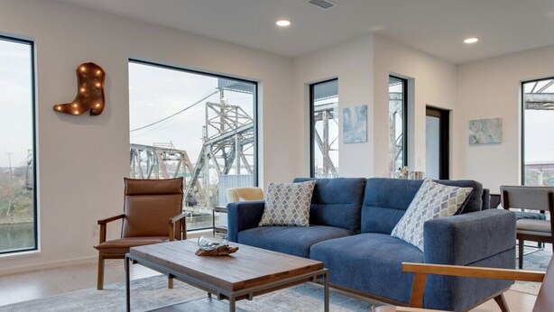 Un salon moderne avec un canapé bleu, une table basse en bois et un fauteuil en cuir marron.