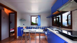 A compact kitchen with a dining area, a window with a view, and a built-in oven.