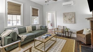 A living room with a green sofa, a coffee table, and a ceiling fan.