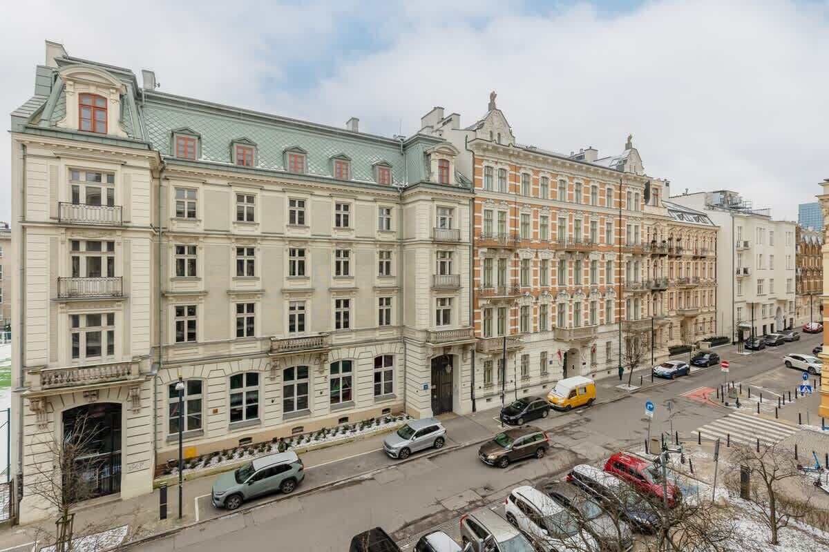 A multi-story building with a classic architectural style, featuring a central entrance with a large doorway and multiple windows on each floor.