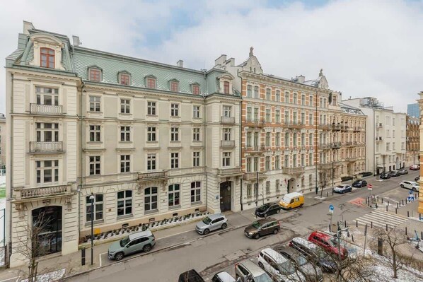 Un immeuble à plusieurs étages, de style architectural classique, doté d’une entrée centrale avec une grande porte et de nombreuses fenêtres à chaque étage.