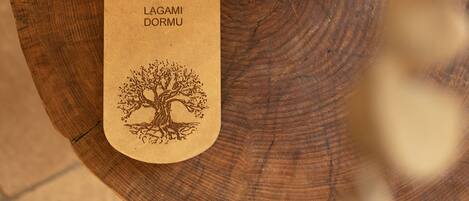 Un posavasos de madera con un diseño de árbol y texto, sobre una superficie de madera.