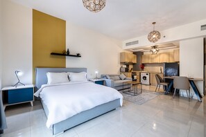 Cozy retreat with a large bed, kitchenette, and natural light.