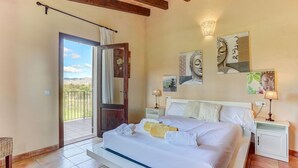 A bedroom with a bed, a nightstand, a wall-mounted lamp, and a door leading to a balcony. - S'Albufereta by Rentallorca (Alcúdia)