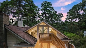 A two-story house with a wooden staircase leading to a balcony. There are string lights hanging across the balcony. - Walk to Town |Hot Tub |Chef Kitchen - The Sunny Spot (Decatur)