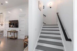 A modern interior with a staircase, a dining area, and a kitchen.
