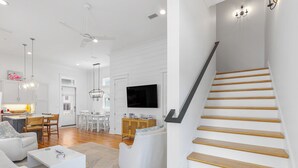Un espace de vie moderne comprenant un escalier, un coin repas et une cuisine.