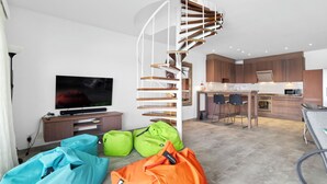 Eine moderne Wohnung mit Wendeltreppe, einer Küche, einem Essbereich und einem Wohnzimmer mit Sitzsäcken.