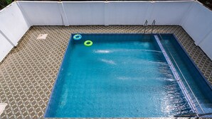 A rectangular swimming pool with a tiled floor and a ladder leading into the water. - Sunlux Grand Residency (Vanur)
