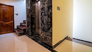 A modern elevator with marble walls and a wooden door. - Sunlux Grand Residency (Vanur)