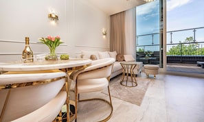Un salon moderne avec une table ronde, des canapés et un balcon offrant une vue agréable.