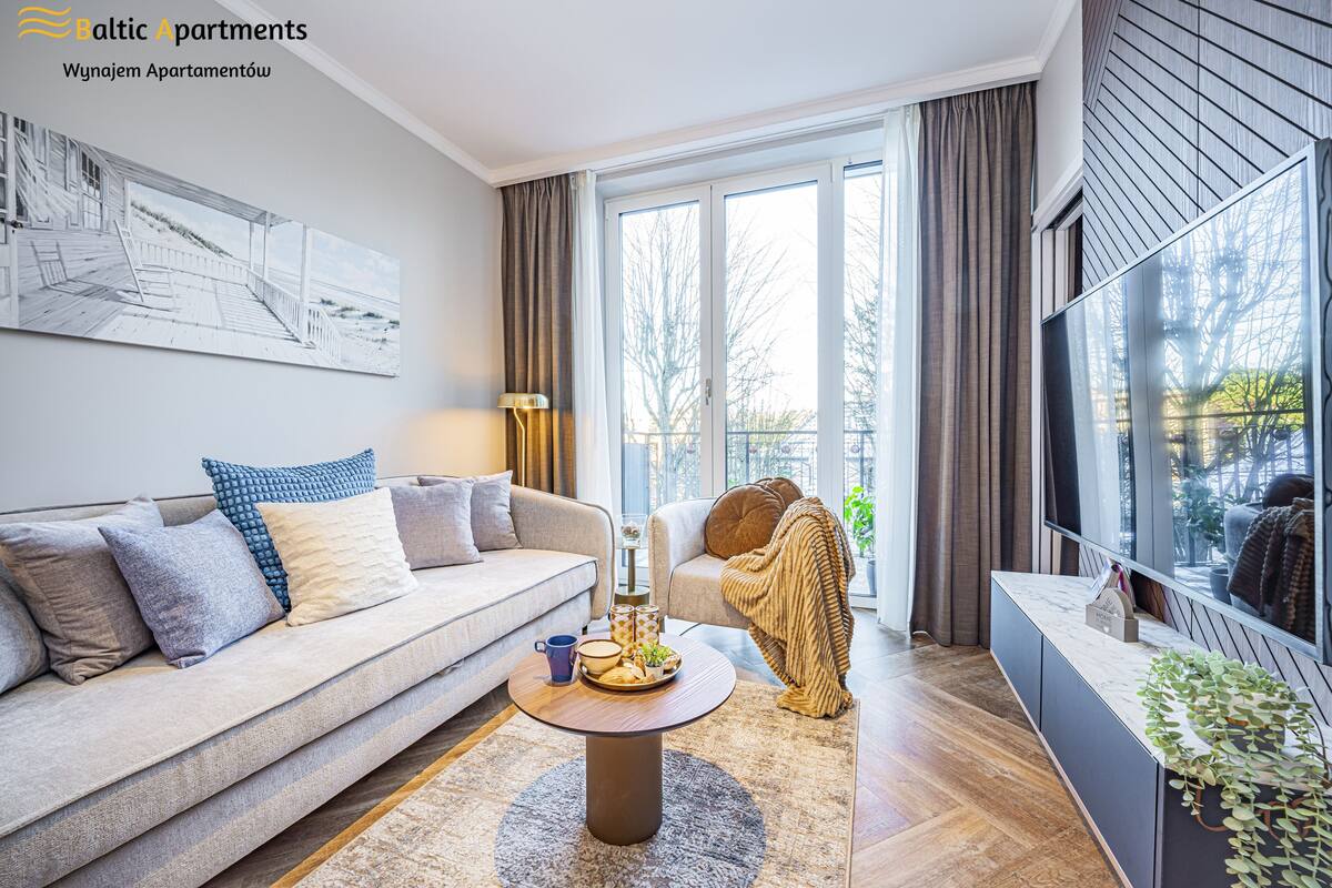Een moderne woonkamer met een bank, salontafel en televisie.