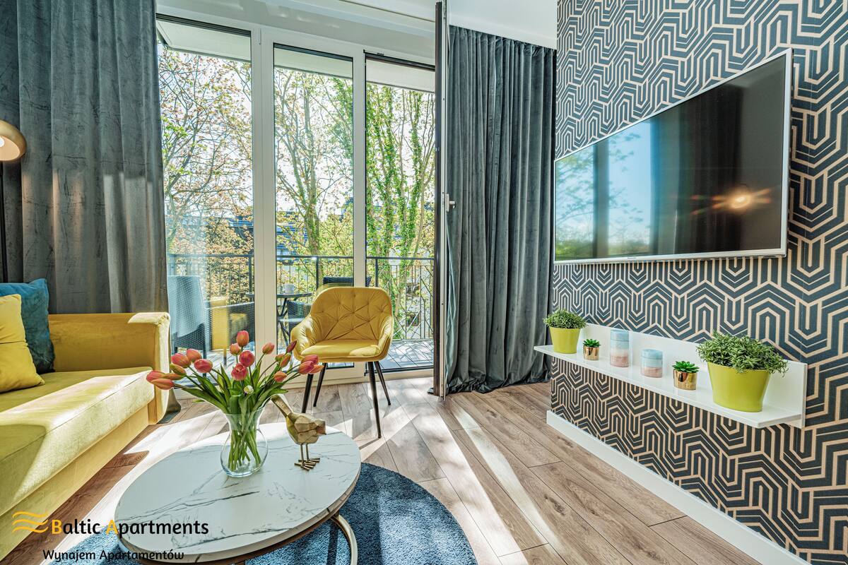 Een moderne woonkamer met een bank, fauteuil en een bijzettafeltje met een bloevas.