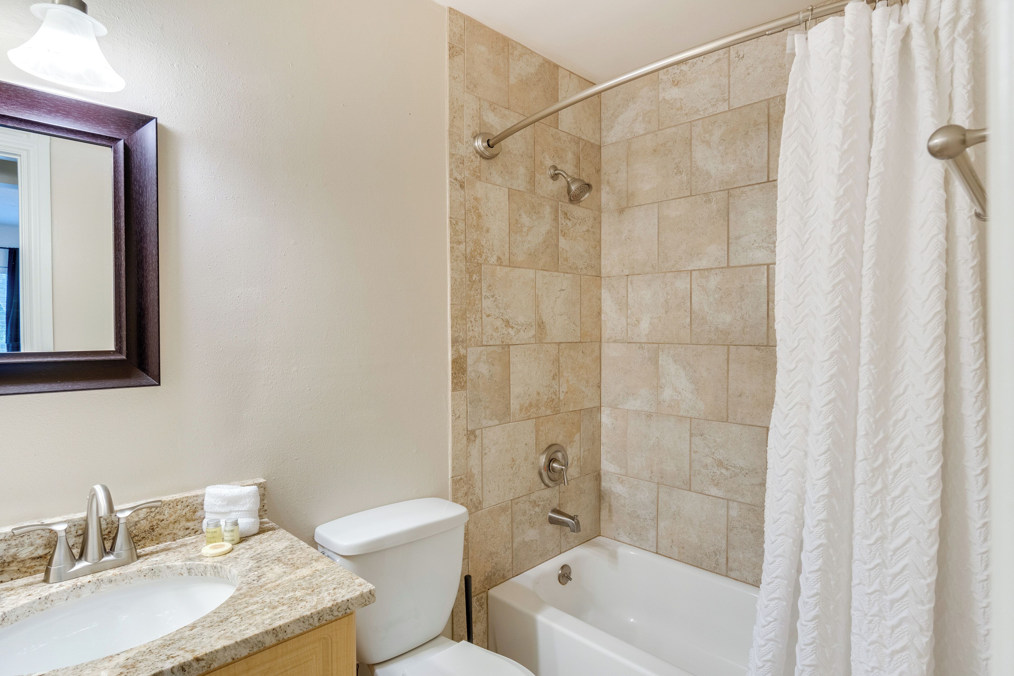 Ein Badezimmer mit Waschbecken, Toilette, Badewanne und Duschvorhang.