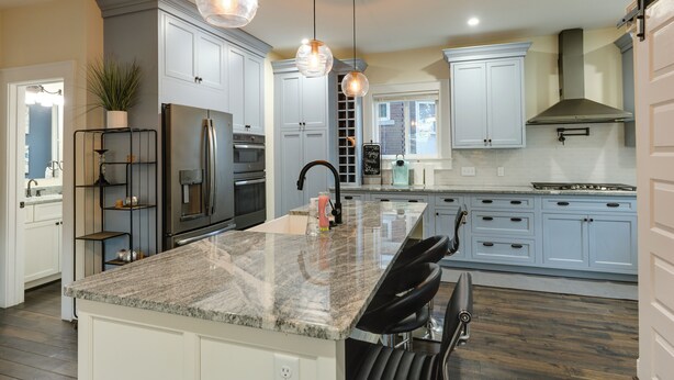 A modern kitchen with granite countertops, stainless steel appliances, and light blue cabinetry. - Charming Cincinnati Home w/ Spacious Deck! (Cincinnati)