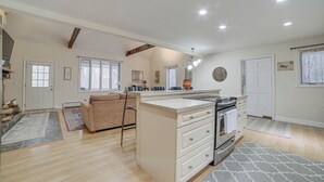 A spacious kitchen with a large island, a dining area with a sofa, and a living room with a fireplace.