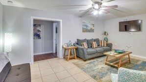 A living room with a grey sofa, a wooden coffee table, and a TV mounted on the wall. - Patio & Grill: Idyllic Sorrento Vacation Home! (Sorrento)