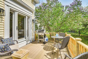 A deck with outdoor furniture, a grill, and a view of a tree with purple flowers. - Charming Wilton Vacation Rental w/ Fire Pit (Wilton)