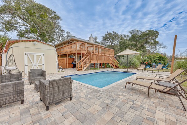 Relax by the pool surrounded by comfortable seating and a covered patio area.