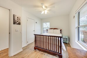 Relax in a spacious room with a large bed, ceiling fan, and a window offering a view of the outdoors.