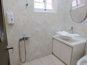 A bathroom with a shower, a sink, and a toilet. - Lunar Mare inn (Liuqiu)