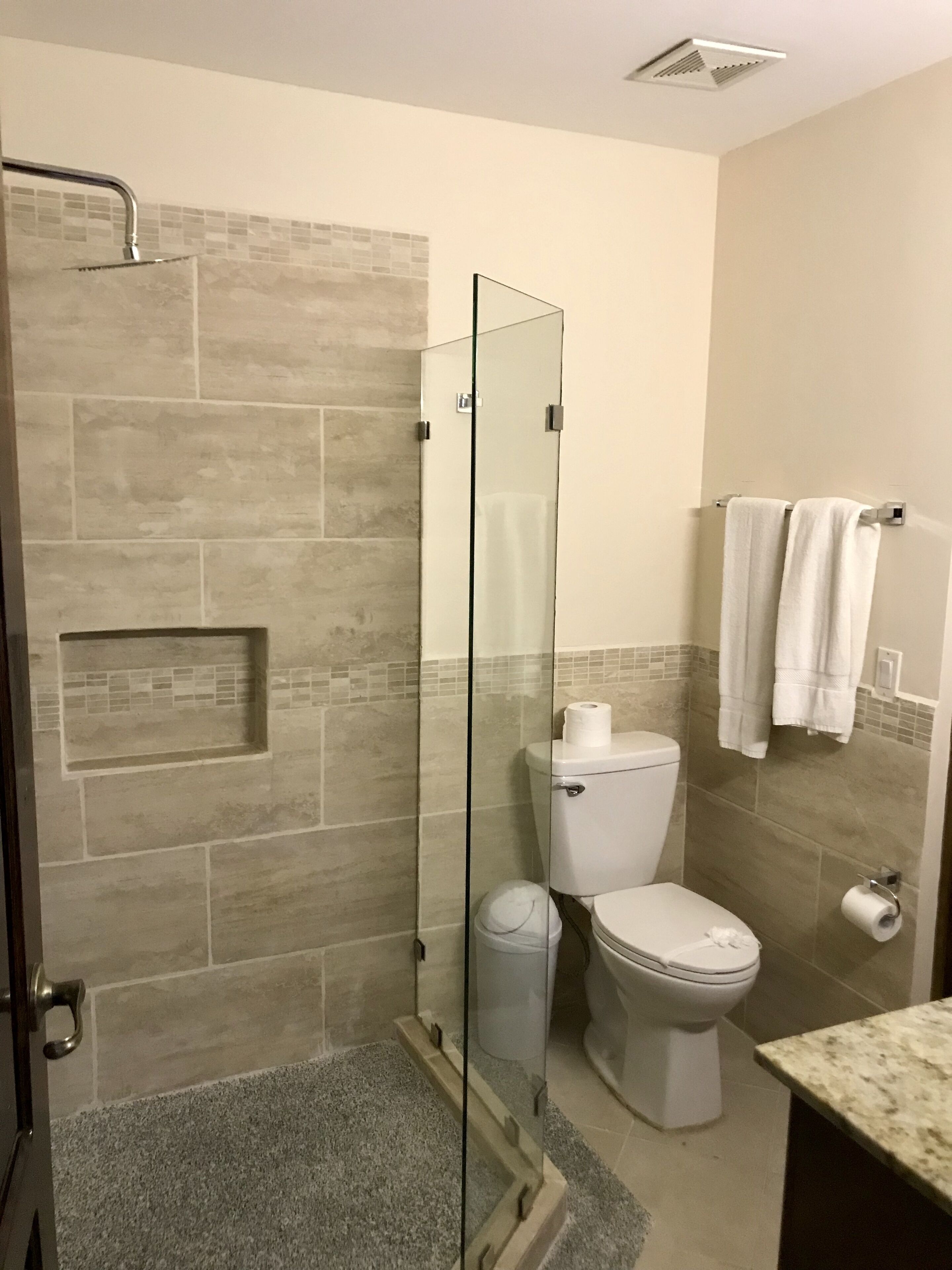 Ein Badezimmer mit Duschkabine, Toilette und Waschbecken.