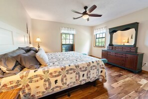 A bedroom with a bed, a dresser, a ceiling fan, and windows. - Little Little 2 Bedroom Cabin by RedAwning (Sevierville)