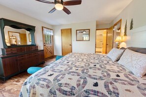 A bedroom with a bed, dresser, ceiling fan, and a large mirror. - Little Little 2 Bedroom Cabin by RedAwning (Sevierville)