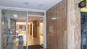 A hotel entrance with a glass door, a wooden wall, and a sign for the Western Union. - Apartamento Céntrico y Luminoso (San Nicolas)