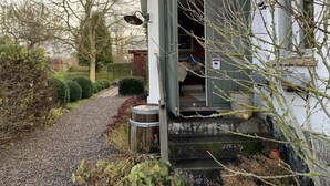 A rustic building with a wooden door, a gravel path, and a small garden area. - Villa Maria Garden Cottages (Morarp)