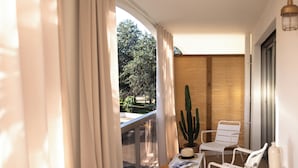 A balcony with white chairs, a table with a hat and a book, a cactus, and a bottle. - MOB Hotel Cannes (Cannes)
