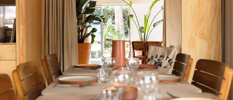 A dining table set for six with a view of the outdoors.