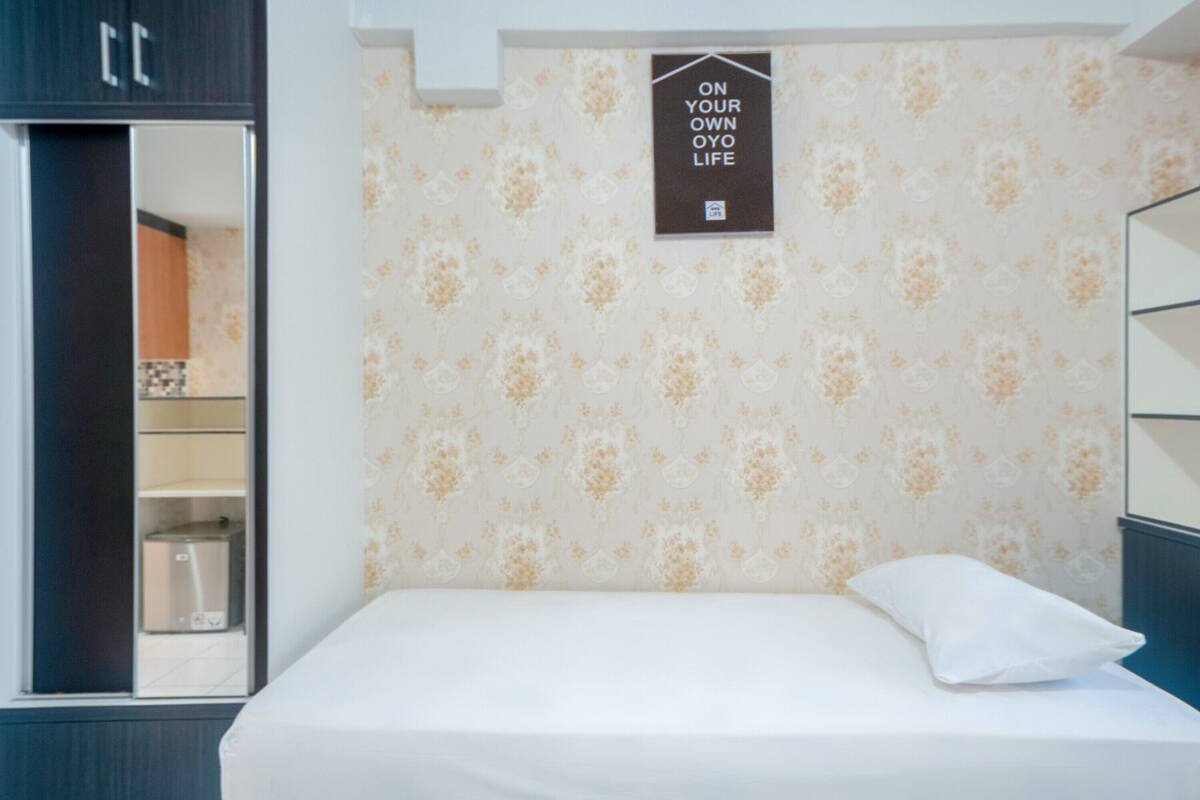 A bedroom with a bed, a pillow, a wardrobe, and a sign on the wall.