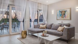 Ein modernes Wohnzimmer mit einem grauen Sofa, einem weißen Couchtisch und einem Elefantenbild.