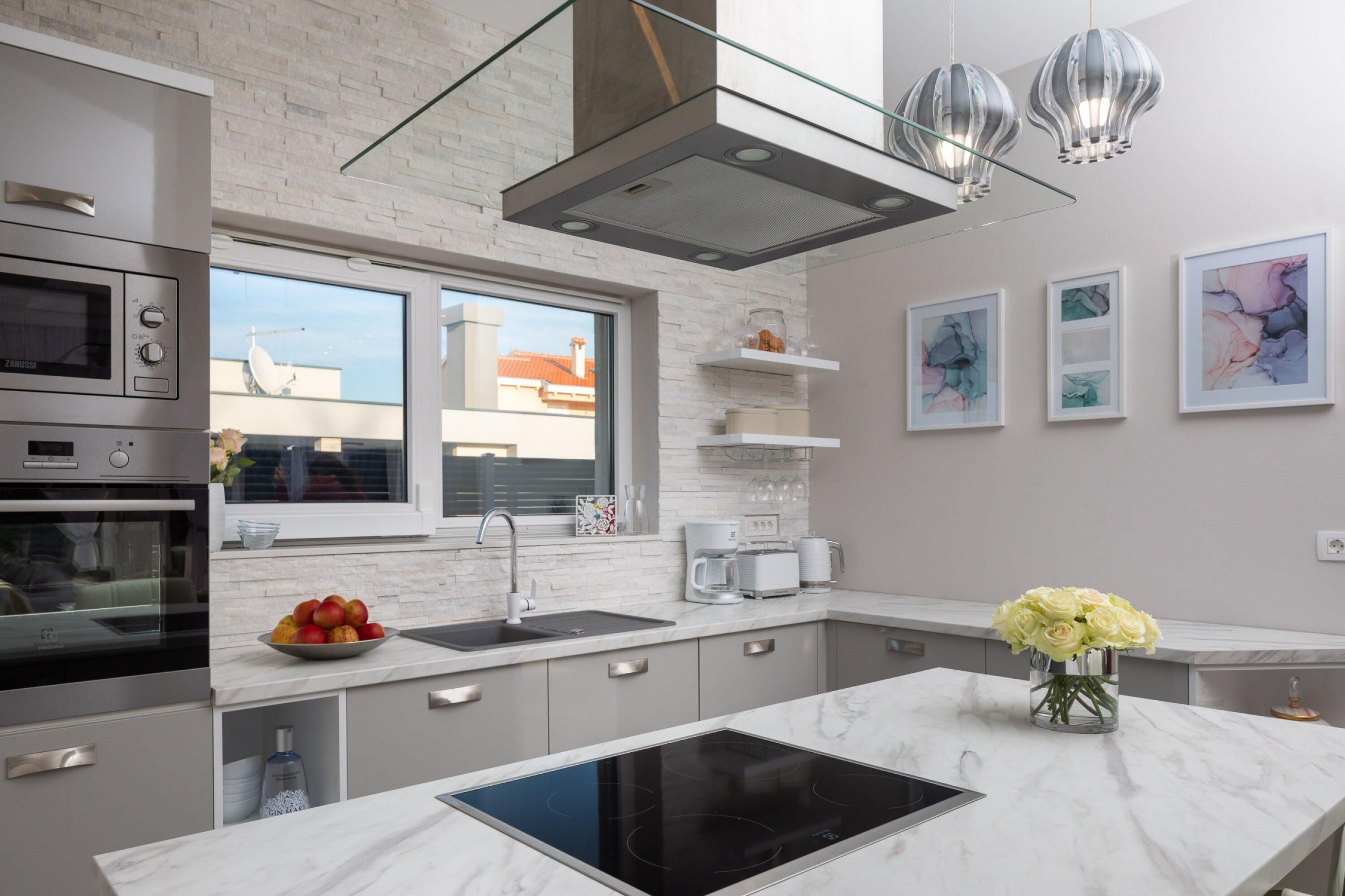 Een moderne keuken met een inbouwoven, magnetron en een groot kookeiland.