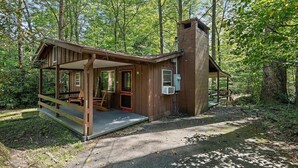 A rustic cabin with a porch, a chimney, and a welcome sign. - Sunflower Shack: 1  BR, 1  BA Cabin / Bungalow in Maggie Valley, Sleeps 2 (Maggie Valley)