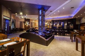 A restaurant with a bar area, tables, and a decorative pillar.