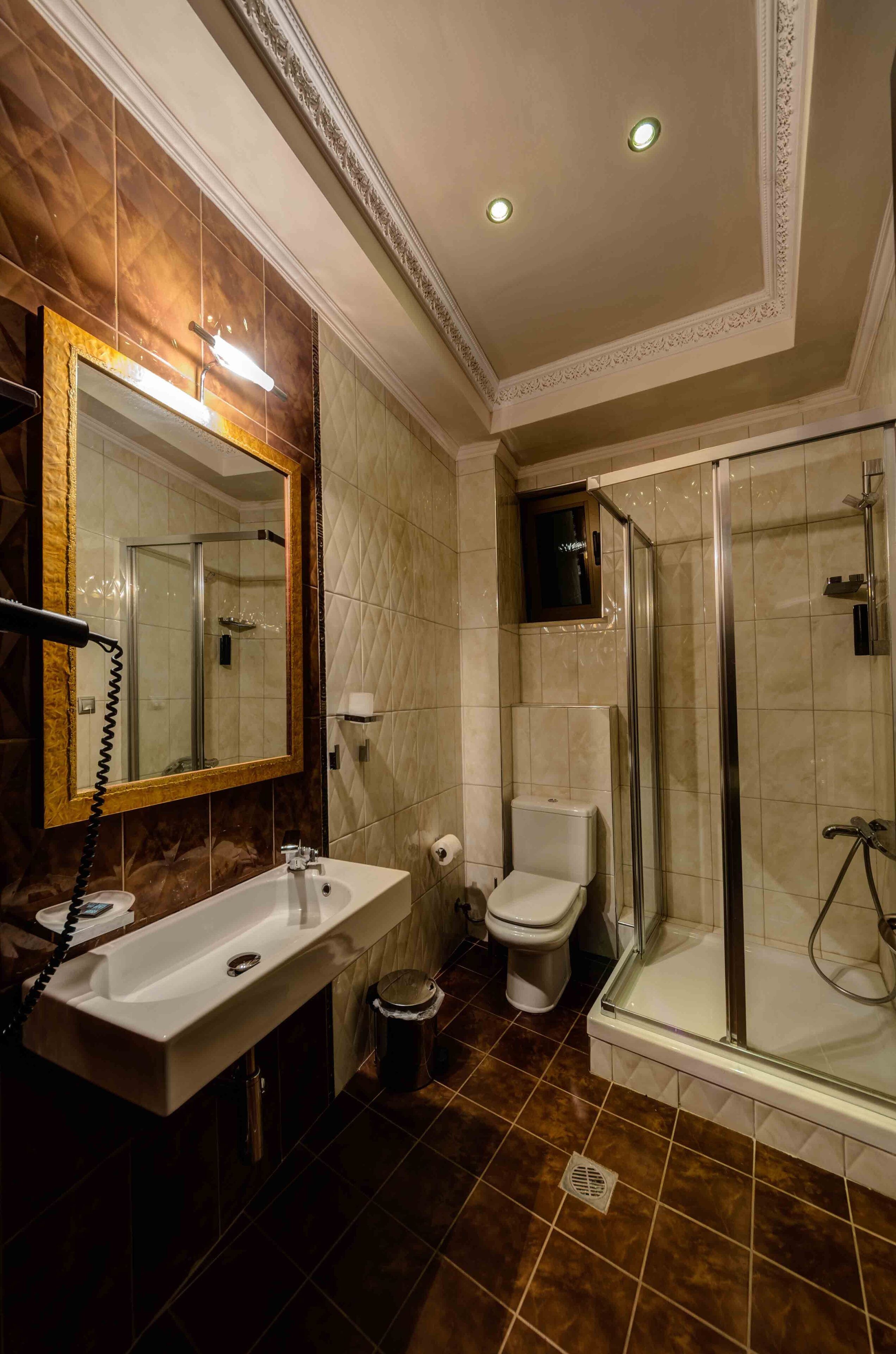 A bathroom with a sink, toilet, and glass-enclosed shower.