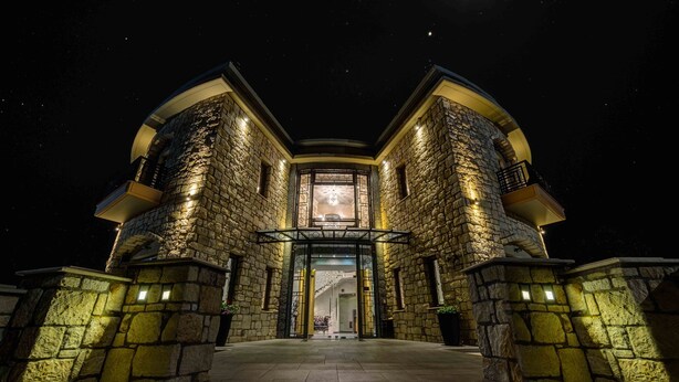 A stone building with a central entrance and two balconies, illuminated at night. - Chateau Rond Boutique Hotel & Spa (Almopia)