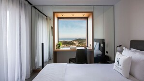 Una habitación de hotel con una cama grande, un escritorio con vistas y una silla.