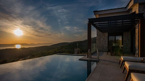 An infinity pool with a view of the sunset over a hilly landscape. - GV Sivota Luxury Villa - SL2022 (Igoumenitsa)