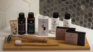 A collection of ZEALOTS of nature products including shampoo, conditioner, body wash, and soap, arranged on a wooden board with a razor and brush. - GV Sivota Luxury Villa - SL2021 (Igoumenitsa)