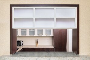 Une cuisine équipée d’un four à micro-ondes, de placards et d’un plan de travail.