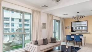A modern living room with a sofa, dining table, chairs, and large windows. - BellaVista - Spectacular - 2 BR Penthouse - Boulevard Central - Panoramic Terrace & Burj Khalifa Vie (Dubai)