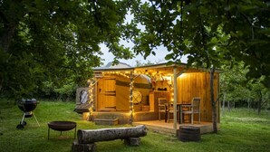 A rustic wooden cabin with a porch, a grill, and outdoor seating. - Torre Cider Farm (Watchet)